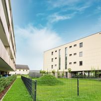 Außenansicht des Gebäudes mit Grünfläche im Vordergrund