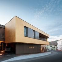 Modernes Gebäude der Bäckerei Reisinger in Gutau mit großzügigen Glasfronten und einer Fassadengestaltung mit CapaGold.