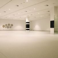 Moderner Ausstellungsraum mit weißen Wänden und Bodenbeschichtung im Schlossmuseum Linz