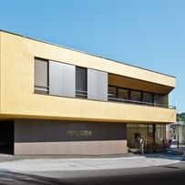 Modernes Gebäude der Bäckerei Reisinger in Gutau mit großzügigen Glasfronten und einer Fassadengestaltung mit CapaGold.