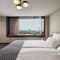 Hotelzimmer mit Doppelbett und Ausblick aus dem Fenster