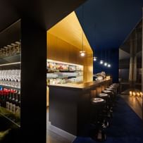 Goldene Bar im gedimmten Licht mit schwarzen Barhockern