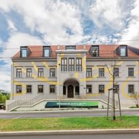 Gesamtes Gebäude und davor verlaufende Straße