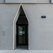 Naufnahme Fassade mit großen, schmalen Eingangstüren, die in einer einzigartigen, spitz zulaufenden Form angeordnet sind