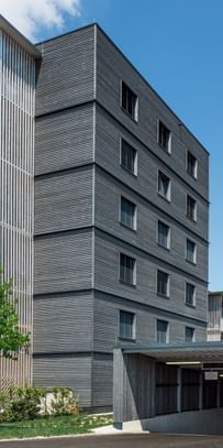 Wohngebäude von außen und Einfahrt in die Tiefgarage