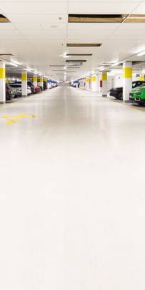 Weiß-gelbe Säulen in der Parkgarage mit parkenden Autos