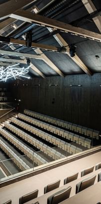 Auditorium von oben mit Spitzdach und Deckenlichtern