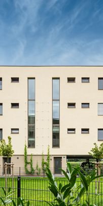 Außenansicht des Gebäudes mit grüner Rasenfläche vor dem Gebäude