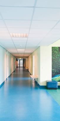 Hygienisch, freundlich, sicher – Klinikflur mit pflegeleichtem, blauem Boden und Naturbild