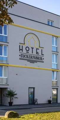 Blick auf das Hotel Zuckerfabrik mit goldenen Fassadenelementen
