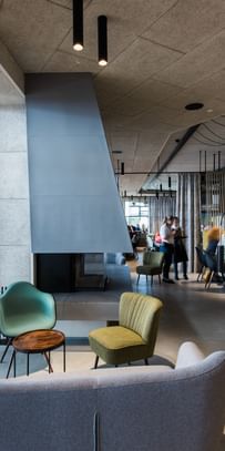 Innenraum des Restaurants mit grauer Couch und zwei Sesseln 