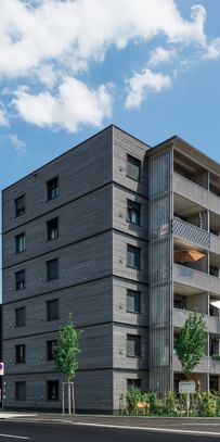 Wohngebäude von außen mit davorstehenden parkenden Autos