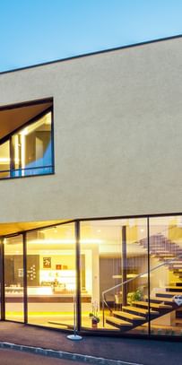 Modernes Gebäude der Bäckerei Reisinger in Gutau mit großzügigen Glasfronten und einer Fassadengestaltung mit CapaGold.