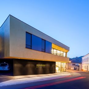 Modernes Gebäude der Bäckerei Reisinger in Gutau mit großzügigen Glasfronten und einer Fassadengestaltung mit CapaGold.