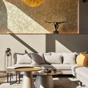 Graue Couch mit beige-grauen Beistelltischen