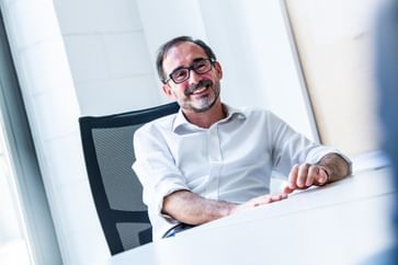 Mann mit Brille lacht herzlich im Gespräch – offen, sympathisch und auf Augenhöhe