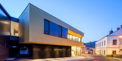 Modernes Gebäude der Bäckerei Reisinger in Gutau mit großzügigen Glasfronten und einer Fassadengestaltung mit CapaGold.