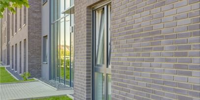 Helle Fassaden mit feinem Steindetail – klar, freundlich und modern inszeniert