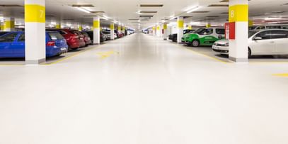 Weiß-gelbe Säulen in der Parkgarage mit parkenden Autos