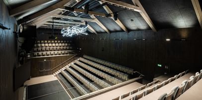 Auditorium von oben mit Spitzdach und Deckenlichtern
