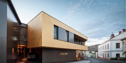 Goldgelber Putz trifft moderne Klarheit – gelungene Fassadengestaltung in urbanem Umfeld