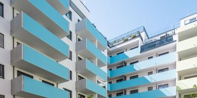 Mehrstöckiges Wohngebäude mit türkisen Balkonen