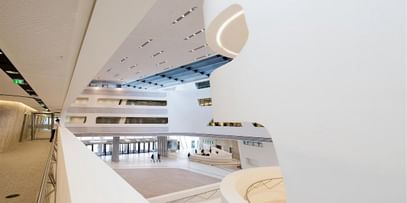 Weißer, futuristischer Innenraum mit fließenden Formen und viel Tageslicht