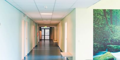 Hygienisch, freundlich, sicher – Klinikflur mit pflegeleichtem, blauem Boden und Naturbild