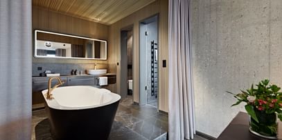 Schwarze Badewanne inmitten eines Hotel-Badezimmers