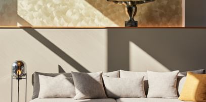 Graue Couch mit beige-grauen Beistelltischen