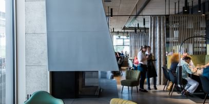 Innenraum des Restaurants mit grauer Couch und zwei Sesseln 