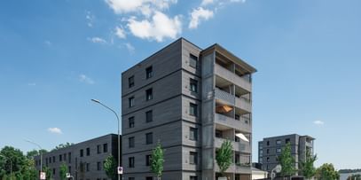 Wohngebäude von außen mit davorstehenden parkenden Autos