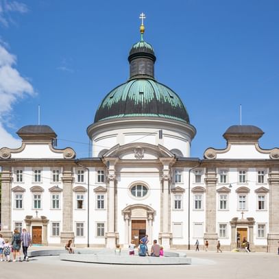 Kajetanerkirche mit spazierenden Menschen im Vordergrund
