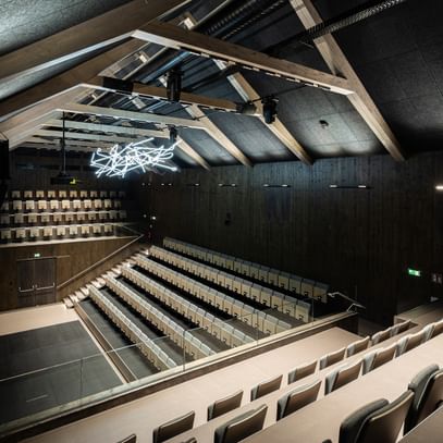 Auditorium von oben mit Spitzdach und Deckenlichtern