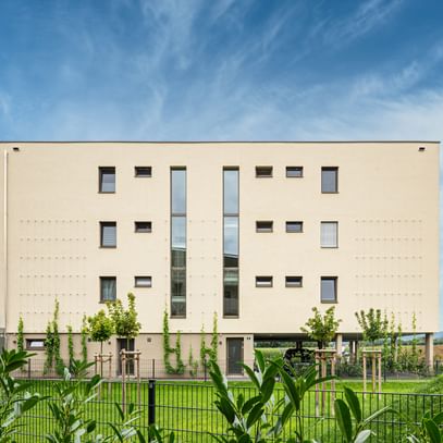 Außenansicht des Gebäudes mit grüner Rasenfläche vor dem Gebäude