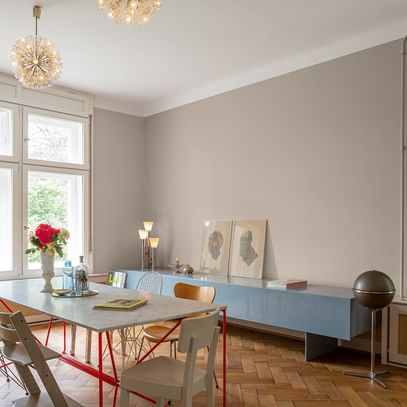 Esszimmer mit Tisch, sechs Stühlen und blauem Sideboard