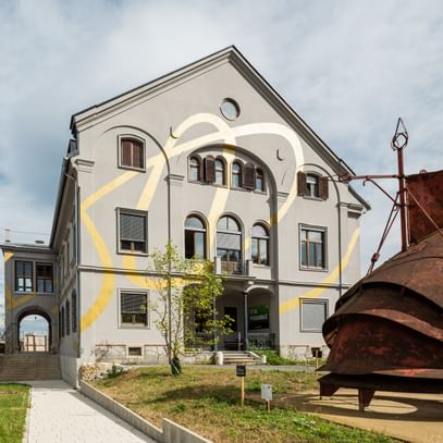 Gebäude mit Goldekoration und einer davorstehenden rostigen Stahlkonstruktion