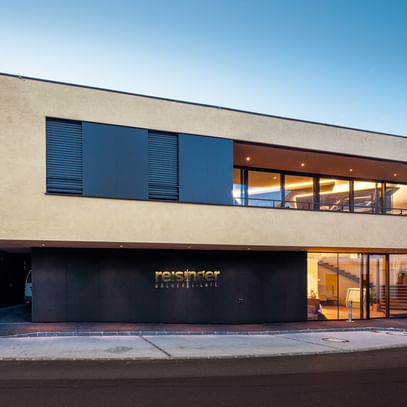 Modernes Gebäude der Bäckerei Reisinger in Gutau mit großzügigen Glasfronten und einer Fassadengestaltung mit CapaGold.
