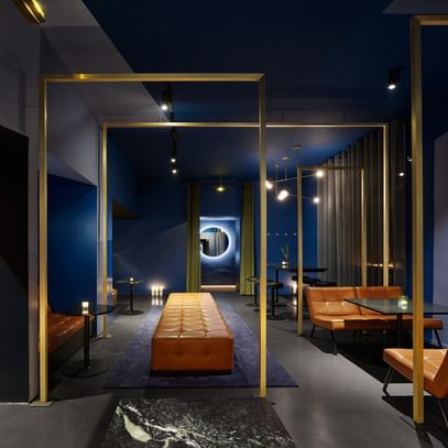 Lounge mit blauen Wänden, braunen Sesseln und goldenen Wandelementen