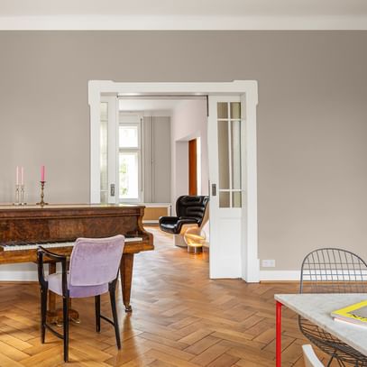 Klavierzimmer mit braunem Klavier und lila Sessel
