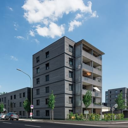 Wohngebäude von außen mit davorstehenden parkenden Autos