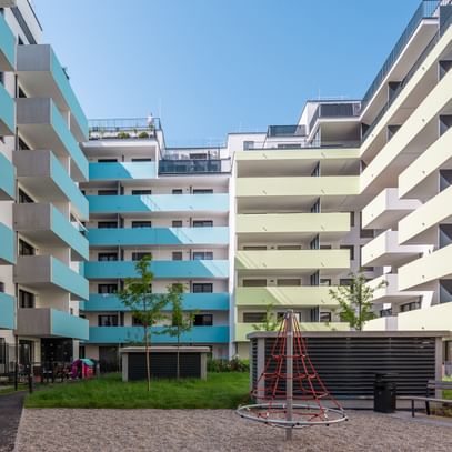 Innenhof von mehrstöckigen Wohnbauten in Wien Brigittenau mit zweifärbiger Fassade