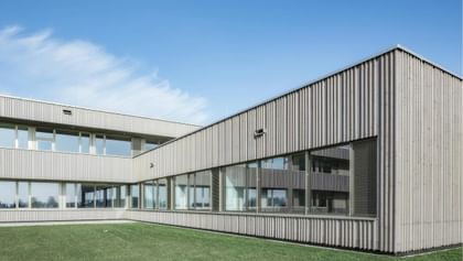 Weitläufige Holzfassade mit großzügigen Fensterbändern – modern und naturnah zugleich