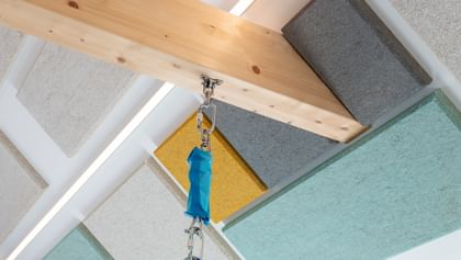 Blick auf den Holzbalken und die bunten Hanfakustik-Platten an der Decke