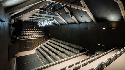 Auditorium von oben mit Spitzdach und Deckenlichtern