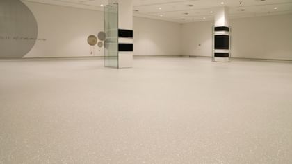 Moderner Ausstellungsraum mit weißen Wänden und Bodenbeschichtung im Schlossmuseum Linz