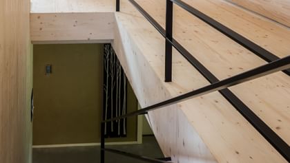 Modernes Treppenhaus aus Holz mit schwarzem Geländer im Passivhaus Scheibbs Neubruck, nachhaltige Architektur, Niederösterreich Landesausstellung