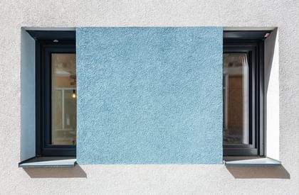 Schmale hohe Fenster mit türkiser Fassade