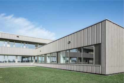 Weitläufige Holzfassade mit großzügigen Fensterbändern – modern und naturnah zugleich
