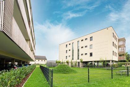 Außenansicht des Gebäudes mit Grünfläche im Vordergrund